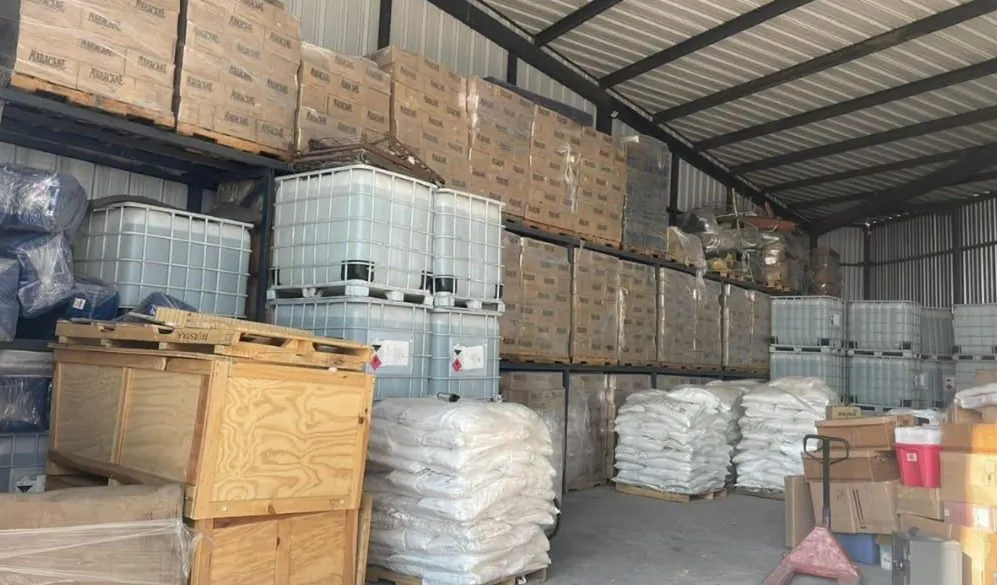 Almacén con racks, tarimas y contenedores de mercancía de clientes.
